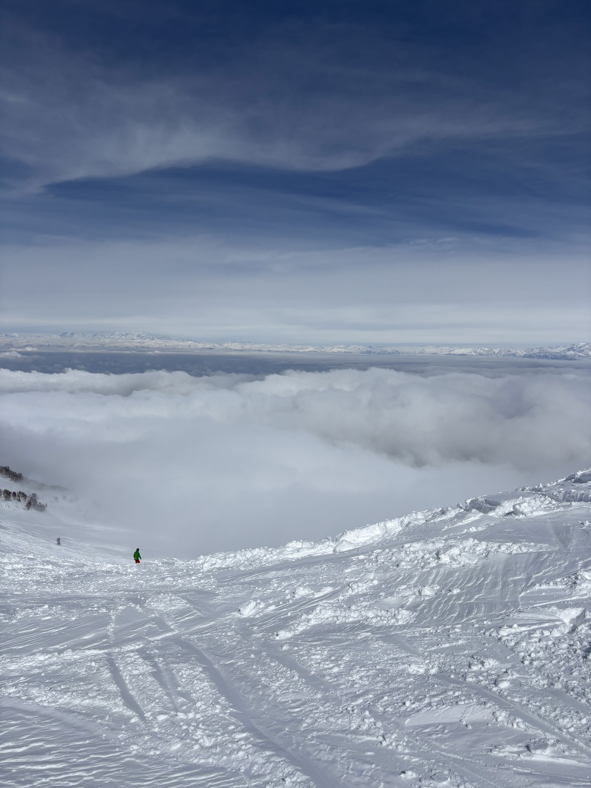 Skier on a high alpine powder face above the clouds in Gulmarg