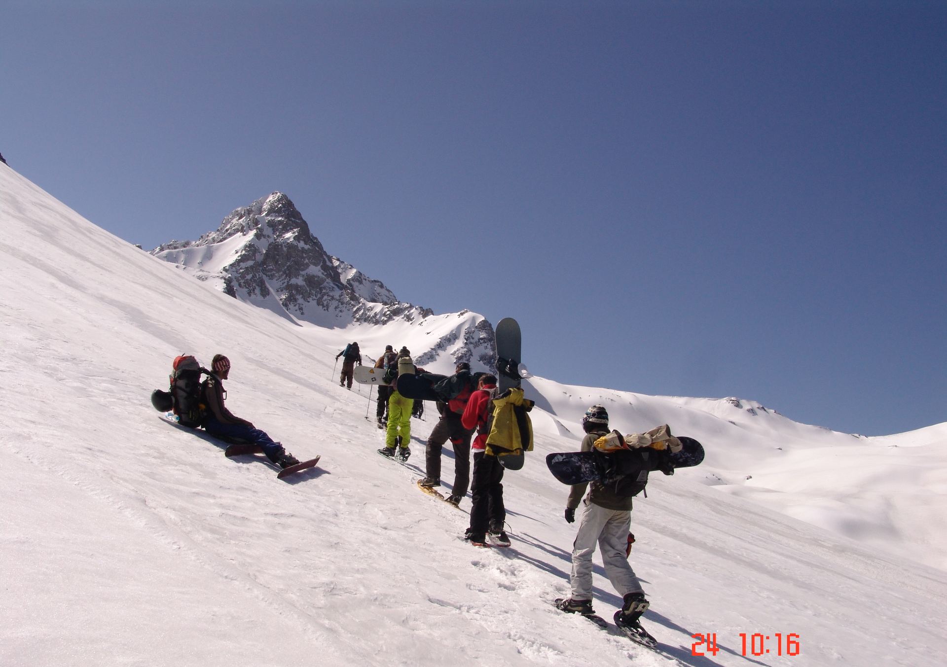 Snowboarder bootpacking a snow slope in Gulmarg